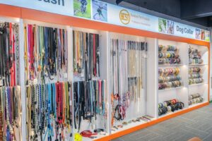 Assorted dog leashes, collars, and accessories on shelves in a pet store display.