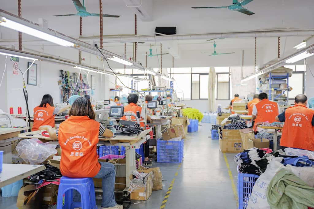 Workers in factory, manufacturing process, sewing machines, orange uniforms, organized workspace, production line, industrial setup, teamwork, professional workshop, equipment setup.