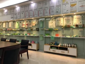 Шоу-рум с экологически чистыми продуктами на полках, сертификатами в рамке на стене и стульями вокруг стола.